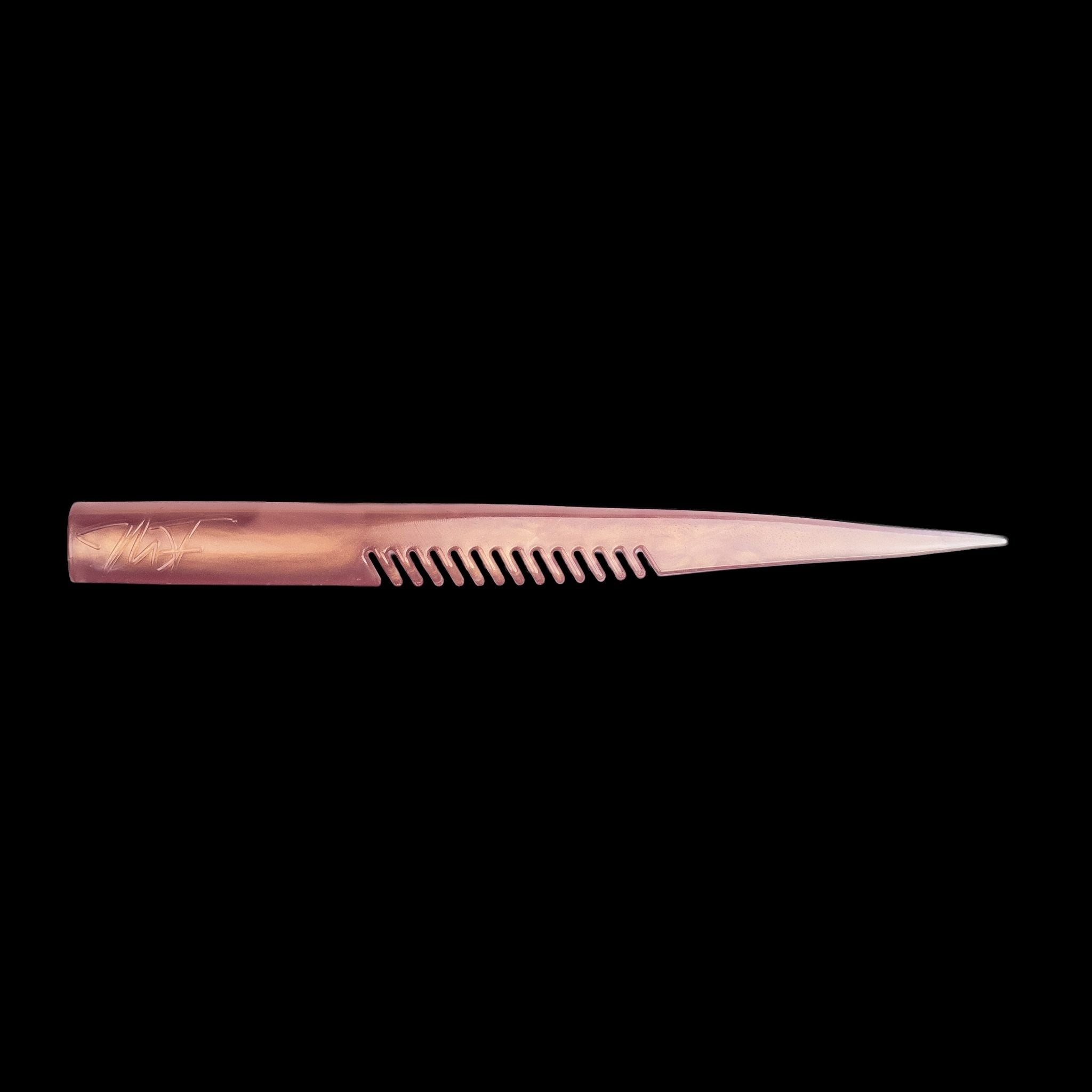 pink comb-like texture fishing lure on a black background