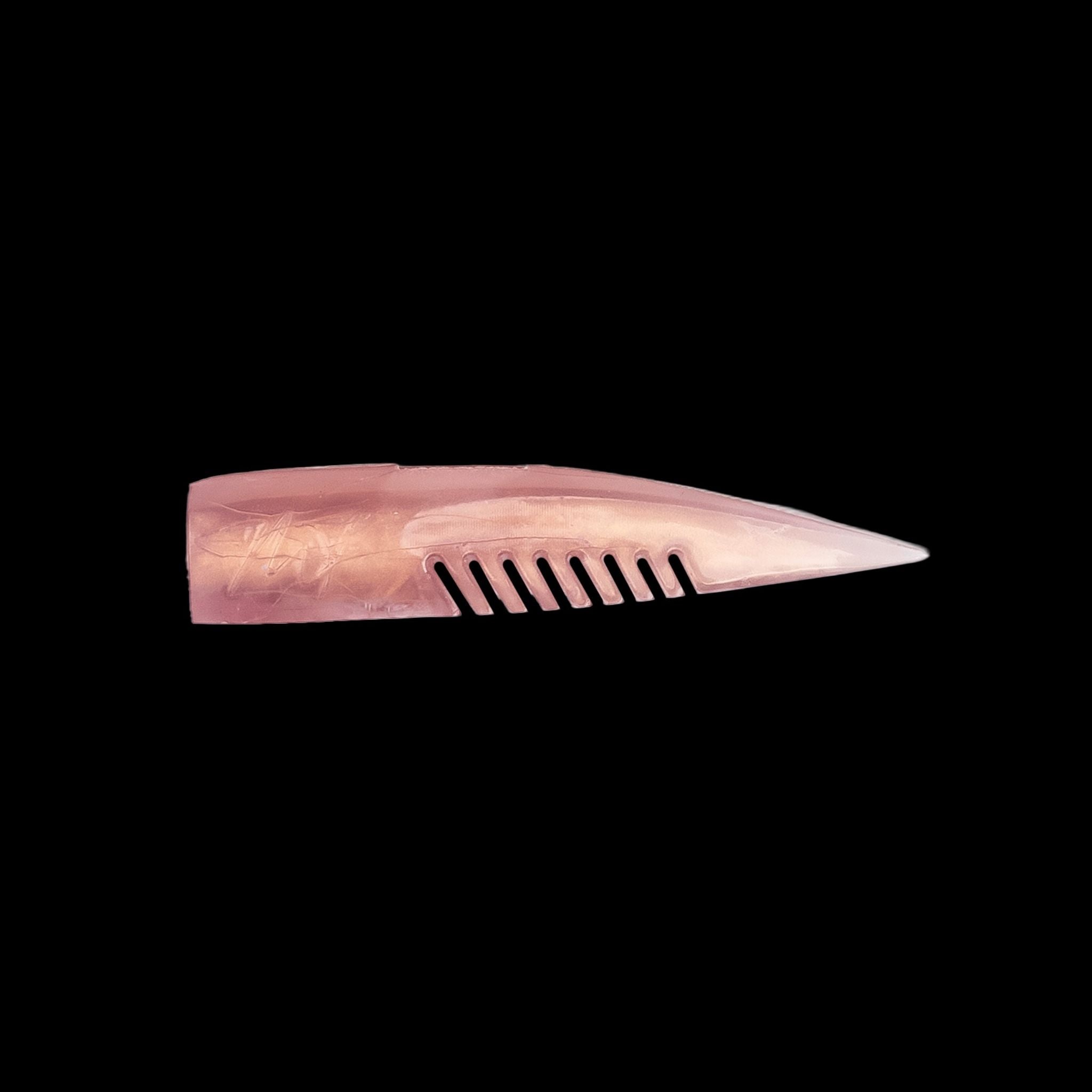 pink comb-like texture fishing lure on a black background