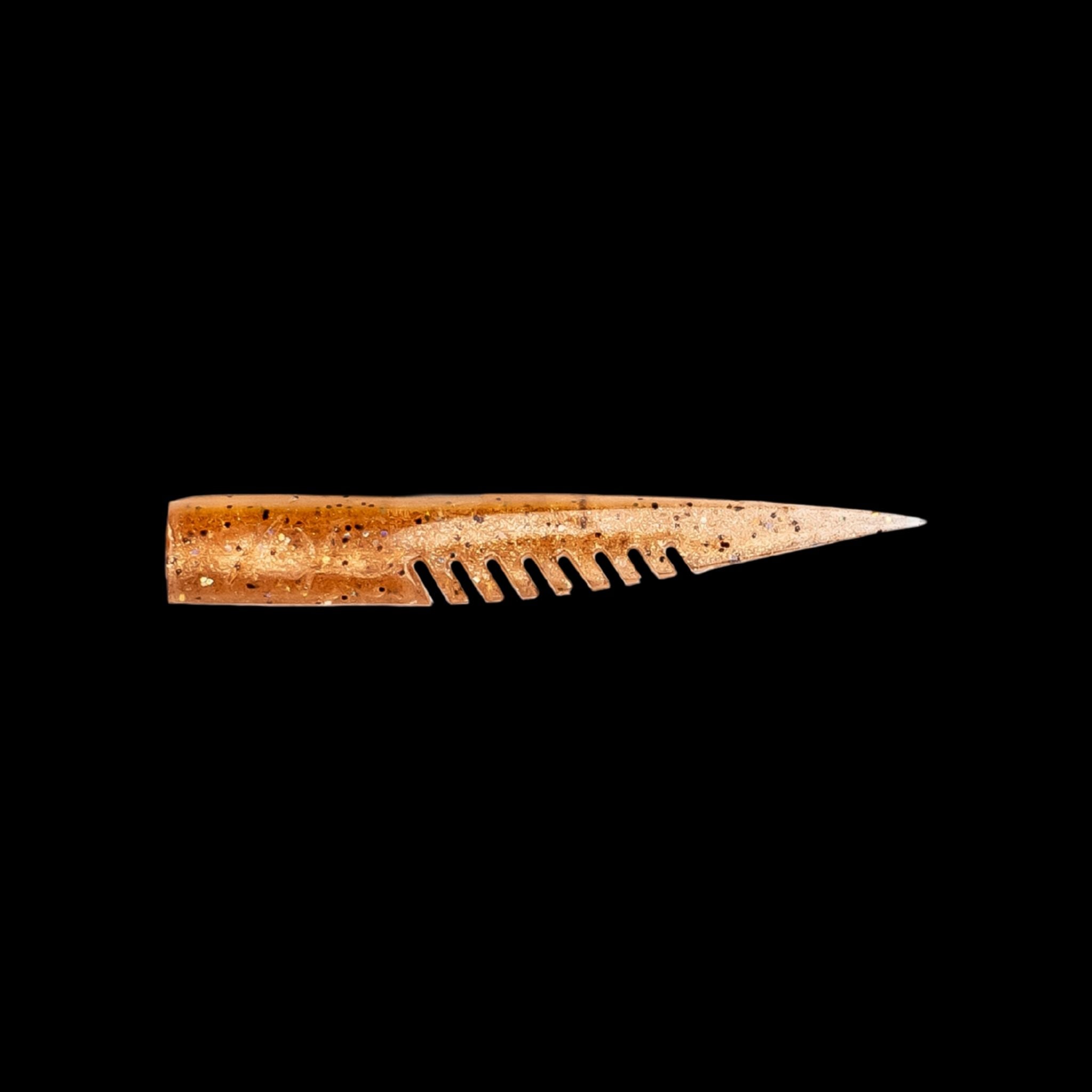 brown fishing lure with a comb-like texture on a black background
