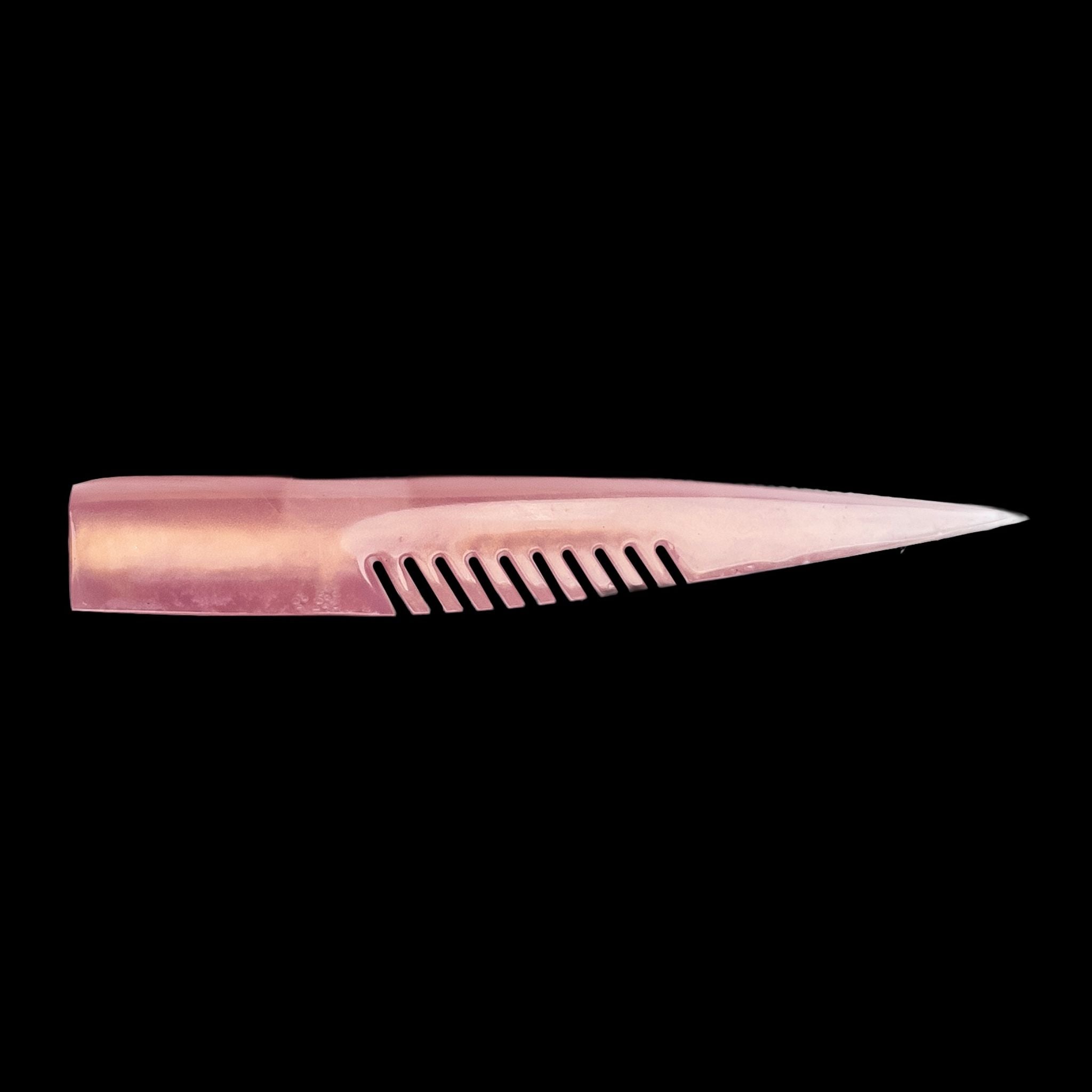 pink comb-like texture fishing lure on a black background