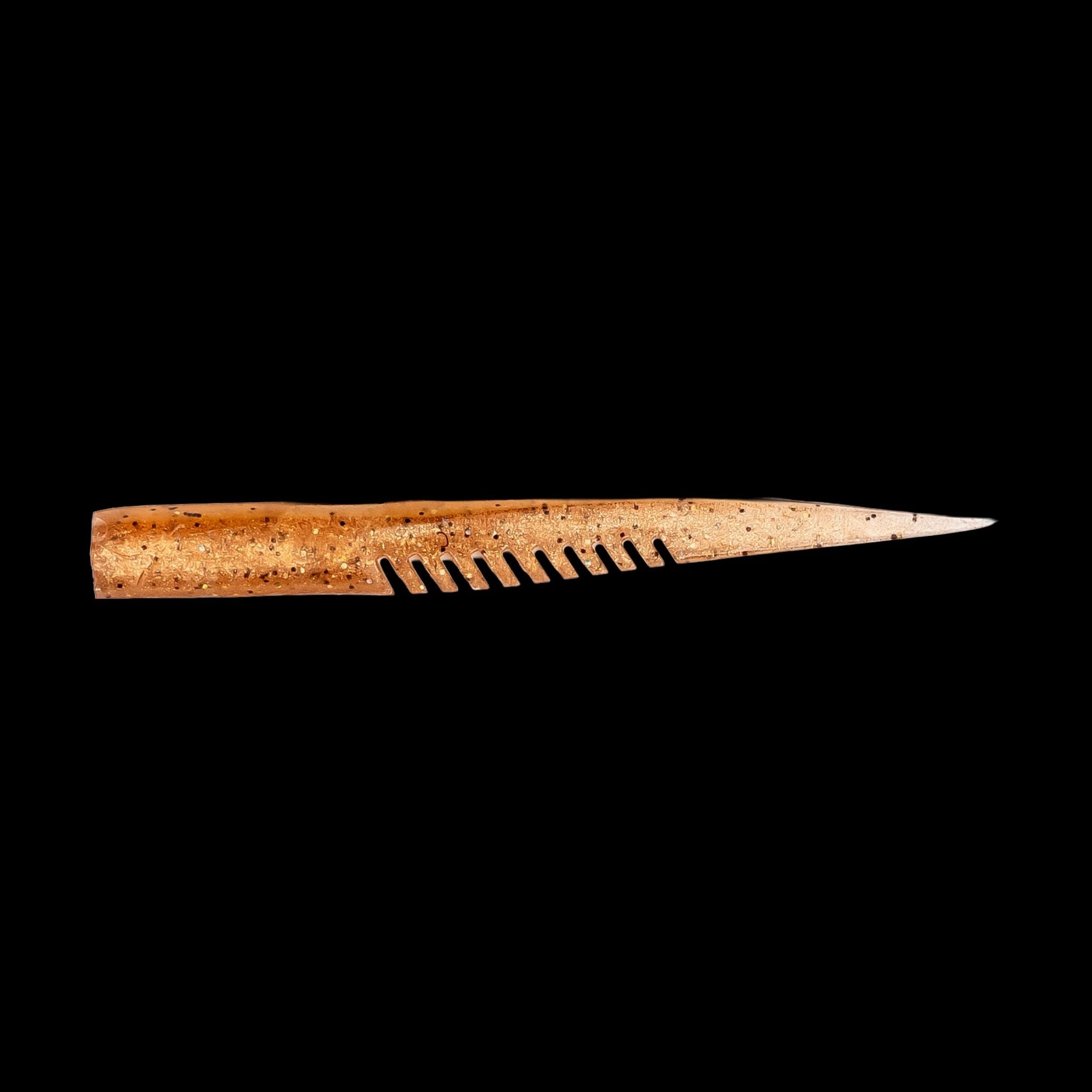 brown fishing lure with a comb-like texture on a black background