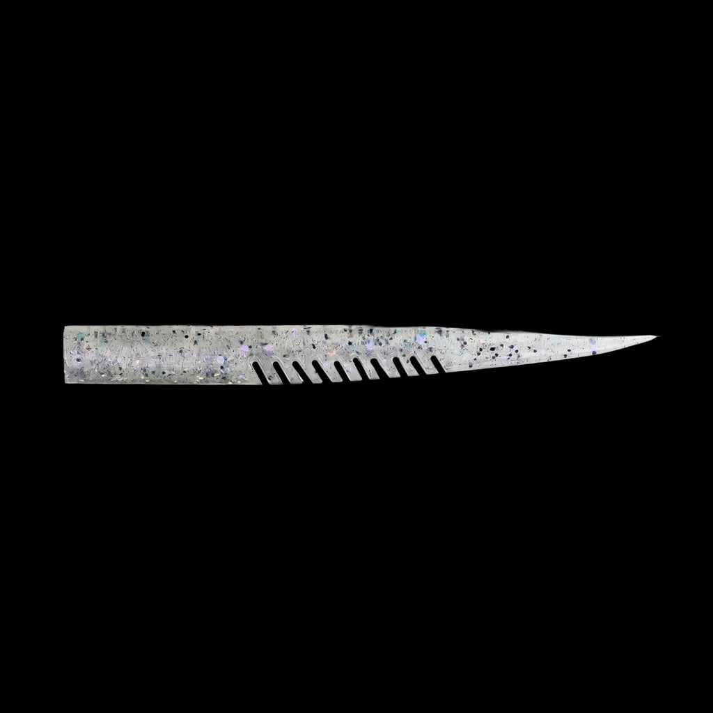silver fishing lure with a comb-like texture on a black background