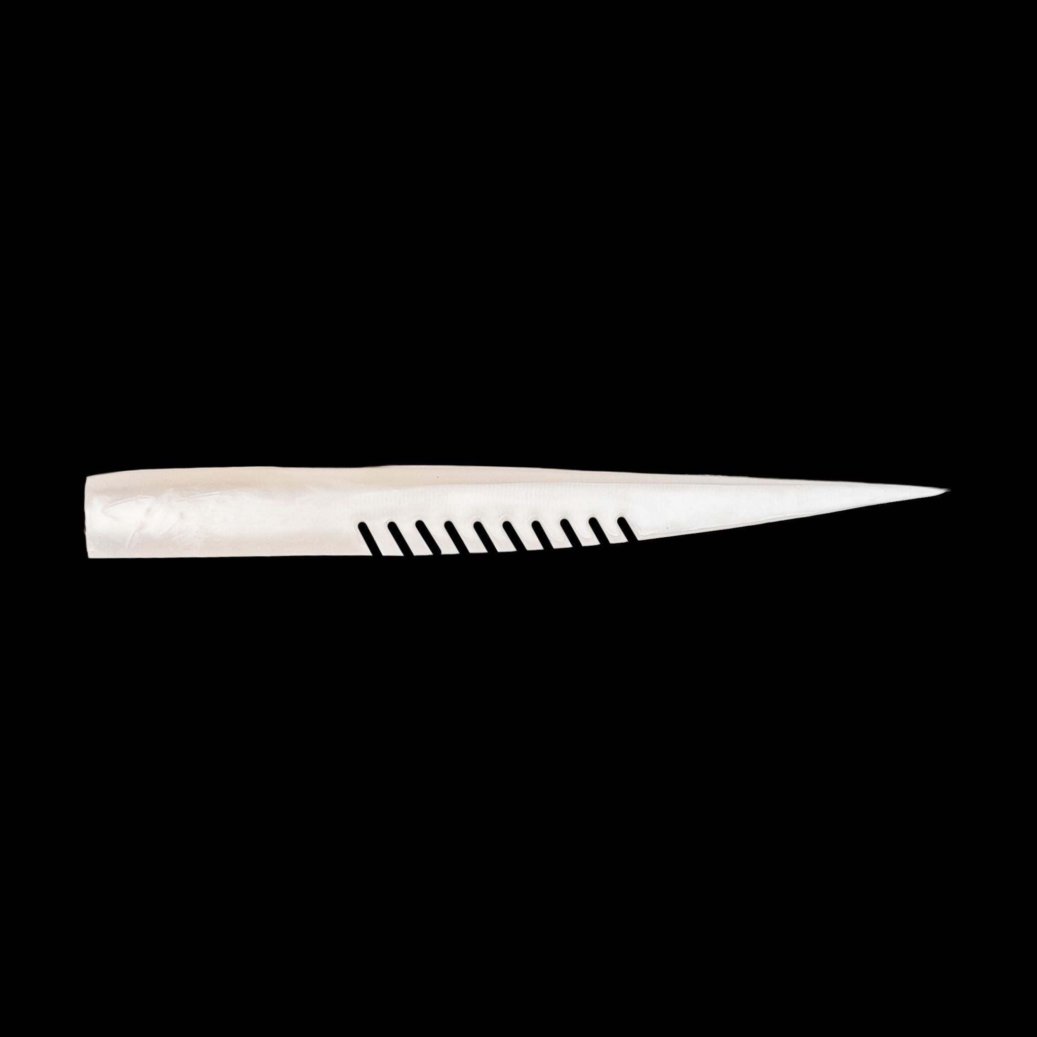 white fishing lure with a comb-like texture on a black background