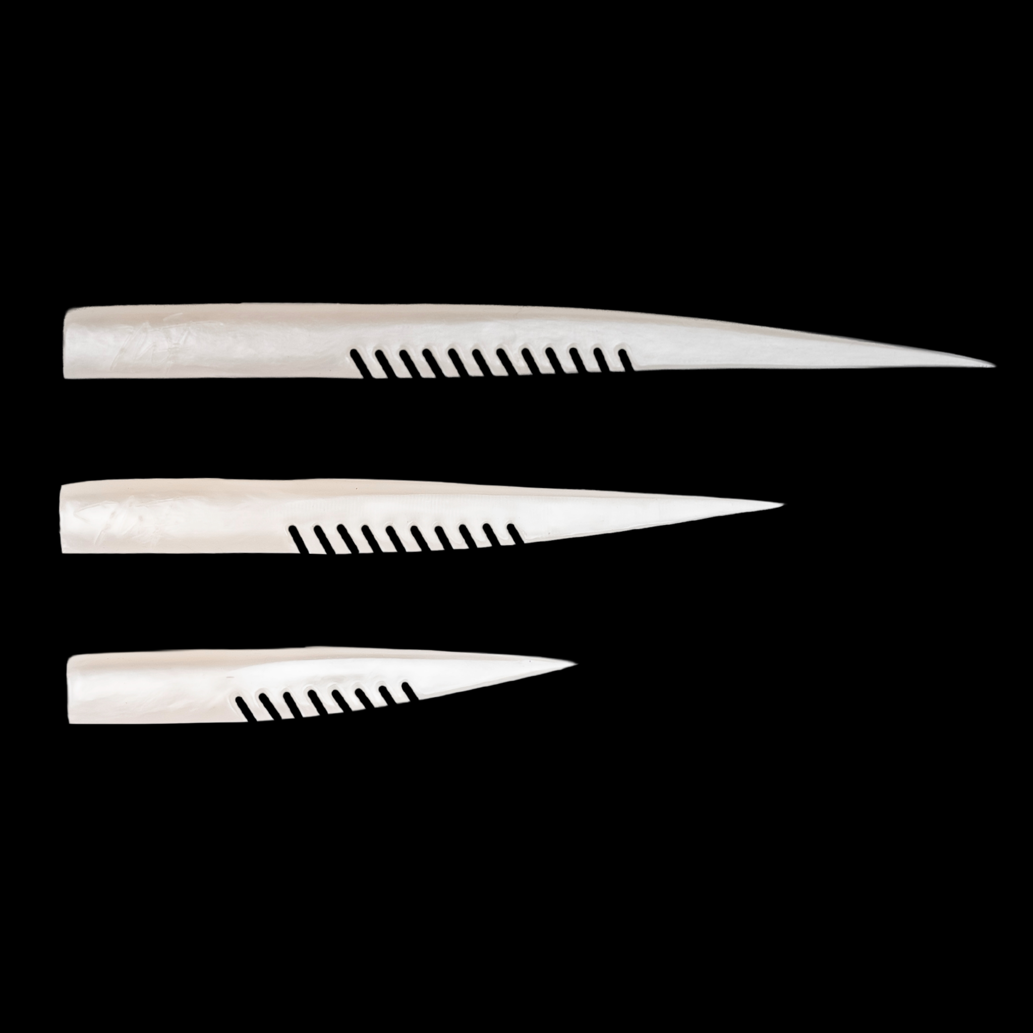 Three white fishing lure with a comb-like texture on a black background